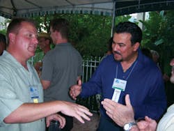 John Eastlack, Canteen Vending Service, St. Petersburg, Fla., left, greets Alberto Velez of Crane Merchandising Systems.
