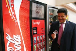 A customer receives a redeemable coupon from a SPIO dispenser.