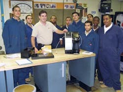 Karl Awalt, Keurig trainer, center, schools the Edison Fareira vending technician students on repairing Keurig equipment. Much of the equipment used in the program is donated from the industry. Pictured from left to right are students Ernesto Sanchez, Luis Martinez, Christopher Torres, Richard Rameriz, William Colon, Victor Correa, Alex Lopez, Kevin Knuckles and Dante Cruz.