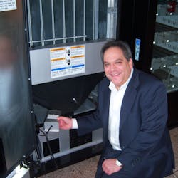 Scott Caputo of Energy Innovative Products Inc. inserts an energy management device in a beverage machine.