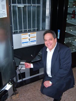 Scott Caputo of Energy Innovative Products Inc. inserts an energy management device in a beverage machine. Scott Caputo of Energy Innovative Products Inc. inserts an energy management device in a beverage machine.