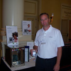 Scott Newell of Apiqe serves attendees water from the countertop water purification system.