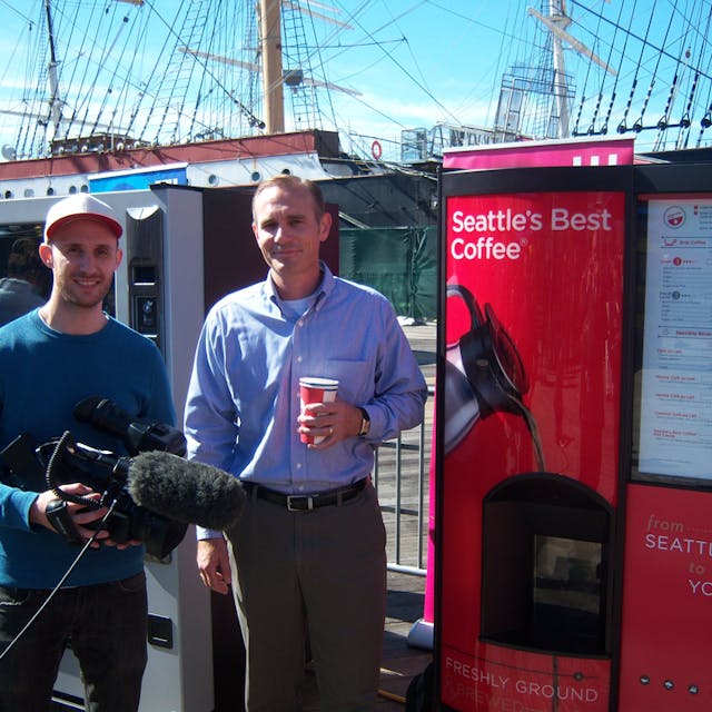 Joe Heavey of Starbucks OCS, right, does an interview for a TV station about the Seattle&rsquo;s Best Coffee machine at the NAMA Gratitude Tour at South Street Seaport in New York City.