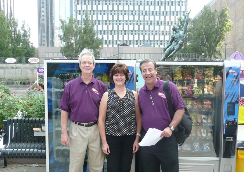 Laura Kelly of P&J's Vending in Hopkington, Mass. joins Dan Mathews of the National Automatic Merchandising Association, left, and John Healy of Healy & Schulte at the first Gratitude Tour in Boston, Mass.
