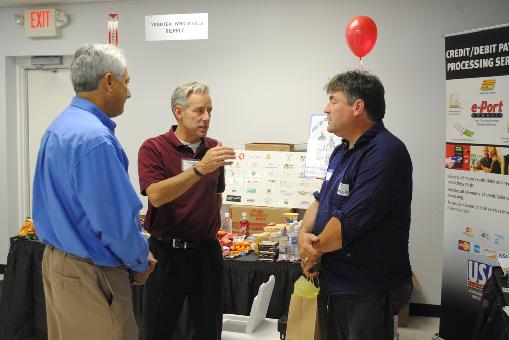 Tom St.Germain of VendTek Wholesale Equipment, center, and Scott Larkin of USA Technologies, left, speak to Dale Krynak of AC Vending.