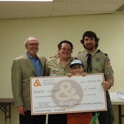 John Leipold, left, of Goetze presents the check to scout leaders Debbie and James Sanders and winning scout James Sanders, Jr.