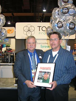 Paul Schindelar, left, Kraft Vending &amp; OCS, presents Steve Jenkins of Midlandtic Vending, Moorestown, N.J., with an Automatic Merchandiser Magazine cover with Jenkins picture during the National Automatic Merchandising Association OneShow at the Sands Expo Center in Las Vegas.
