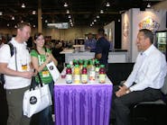 David and Kara Leighton of Quality Vending Systems, left, talk to Ron Moulden of Florida&apos;s Natural Growers, right, about Florida&apos;s Natural juice products.