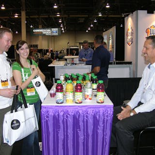 David and Kara Leighton of Quality Vending Systems, left, talk to Ron Moulden of Florida&apos;s Natural Growers, right, about Florida&apos;s Natural juice products.