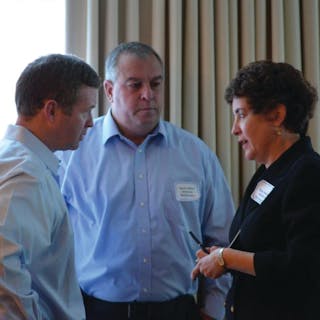 Tom McCarthy (left) and David Jenkins (right) of Coca-Cola Co. speak with Ellen Valentino of the MD-DE-DC Beverage at the 2013 MD-DC Annual Meeting.