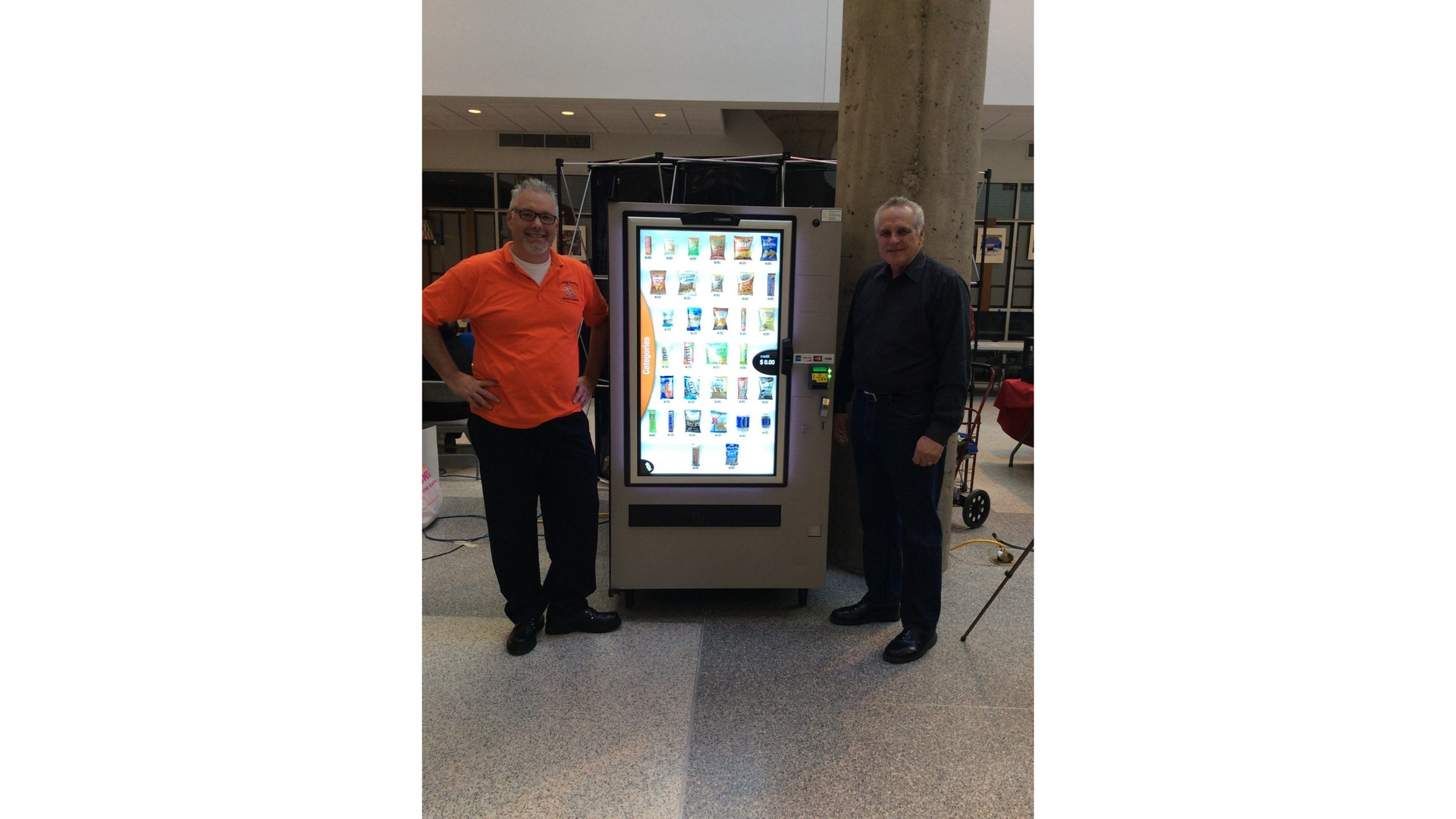 Davis Haines, Vending Technologies Instructor, Randolph Technical High School and Bud Burke, Thayer Distribution, Gibbstown, NJ, Chairman, Vending Technologies Advisory Committee with VEConnect snack machine at CTE Expo.
