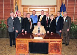 Kansas Governor Sam Brownback (center), surrounded by Mike Cox, John Barnes, Denny Burgess, Chip Stephenson, Joe Hemmelgarn, Claude Bockhold, Bill Bradford, Sandy Larson, Keith Bottorff and Tom Burgess.