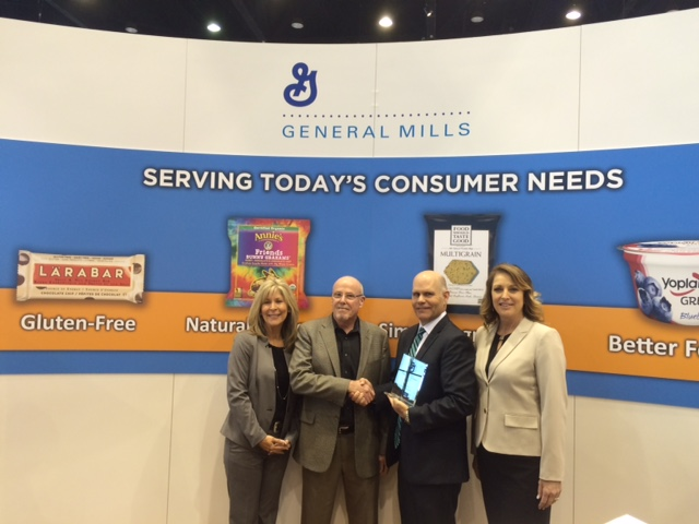 Tom Ganley of BBI Pacific accepts the General Mills 2016 West Region Broker of the Year honor at the recent NAMA OneShow. Pictured from left to right are; Lisa Mattias (BBI), Mark Kelley (General Mills West Region Sales Manager), Tom Ganley (BBI Pacific Region Manager), and Wendy King (BBI).