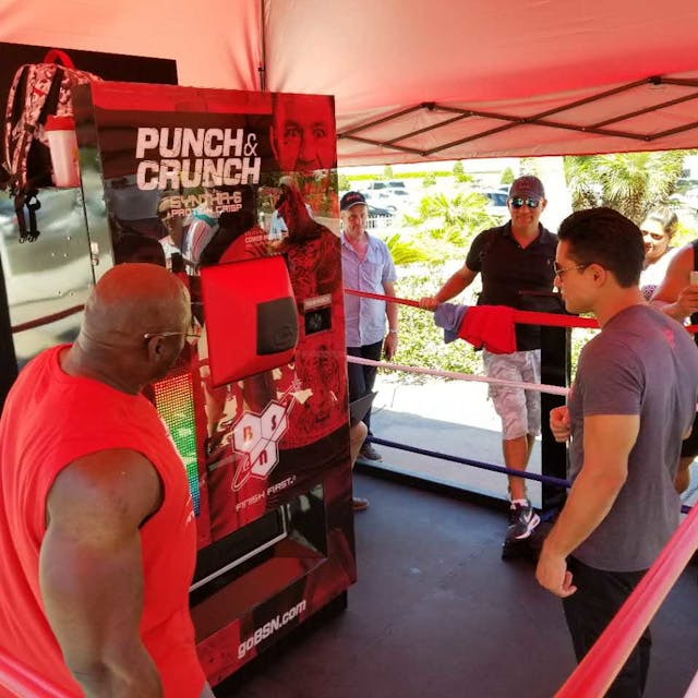 TV Host Mario Lopez was the first to try the punch the McGregor/Mayweather fight promotional vending machine created by American Vending Machines, Inc. and Digital Media Vending.