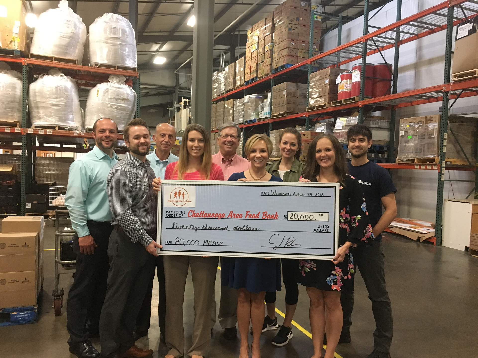At the Chattanooga Area Food Bank Warehouse, President and CEO Gina Crumbliss (center right) and Director of Development Sarah Aligo (front row, far right) and team receives a donation from Danelle Layton (center left) and C.J. Recher (front row, far left) of the Five Star Food Services Team on behalf of Feeding the Future.