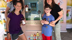 A family checks out the Honest 'Up Your Impact' vending machine at Chelsea Piers in New York City.