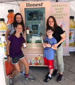 A family checks out the Honest &apos;Up Your Impact&apos; vending machine at Chelsea Piers in New York City.