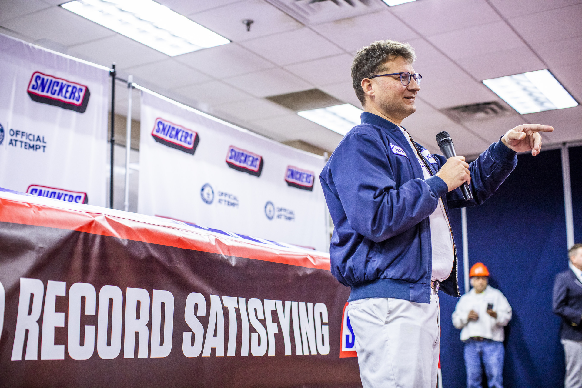 Mars Wrigley representative Ruud Engbers unveils the largest SNICKERS bar ever created Thursday, Jan. 16, 2020, in Waco, Texas. The more than two tons chocolate nut bar was made using a 1200 pound combination of caramel, nougat and peanuts, and 3500 pounds of chocolate.