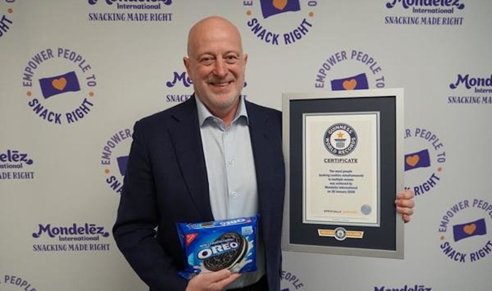 Dirk Van de Put accepts Guinness World Records title certificate for most people dunking cookies across multiple venues.