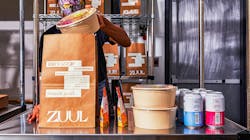 A Zuul employee prepares a Zuul Market order for delivery. A Zuul employee prepares a Zuul Market order for delivery.