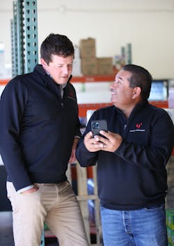 Director of route operations, Franco Benitez (right), talks Michael Lovett through a warehouse pick list for one of the day’s stops. Director of route operations, Franco Benitez (right), talks Michael Lovett through a warehouse pick list for one of the day’s stops.