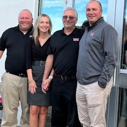 Larry Bach, Barbie Nesser, Tom Nesser and Tom Bach at the main entrance of their Rochester, New York, headquarters.