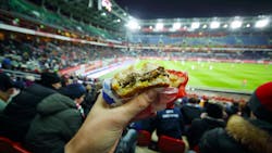 man eating hamburger in football stadium man eating hamburger in football stadium