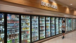 A customer looks at the drink choices in the beverage cooler in a convenience store. A customer looks at the drink choices in the beverage cooler in a convenience store.