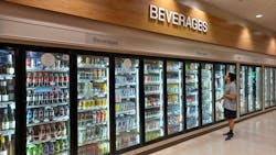 A customer looks at the drink choices in the beverage cooler in a convenience store. A customer looks at the drink choices in the beverage cooler in a convenience store.