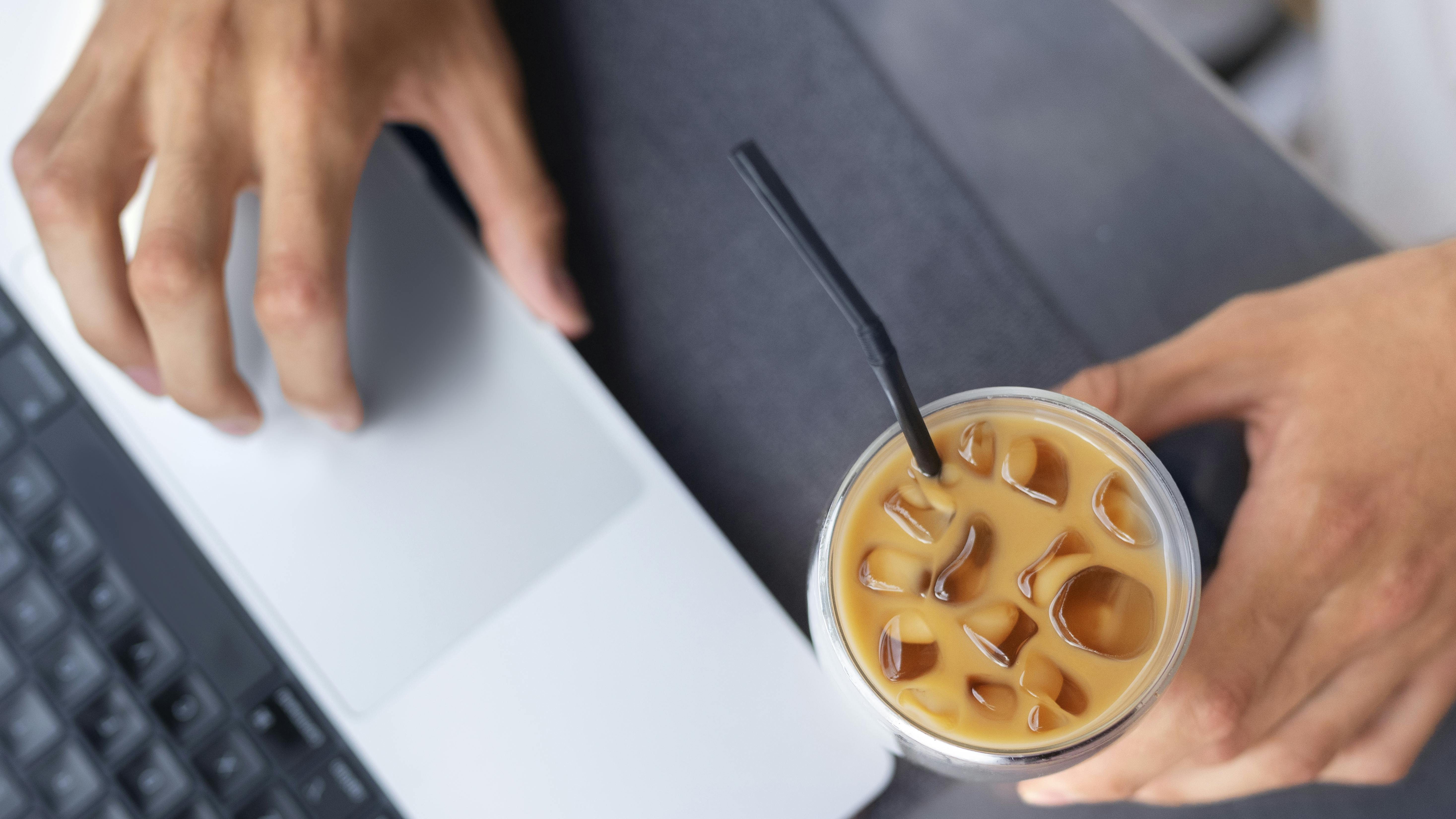 stock image freepik woman having iced coffee at computer