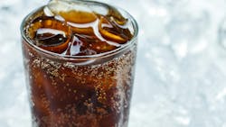 cola in a glass in front of ice cola in a glass in front of ice