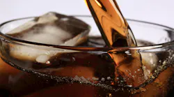 Photo of soda pouring into a glass of ice.