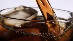 Photo of soda pouring into a glass of ice. Photo of soda pouring into a glass of ice.